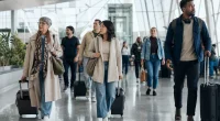 Resenärer med resväskor i en flygplatsterminal under högsäsong
